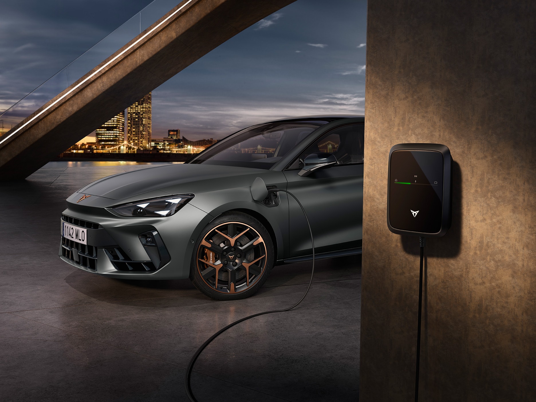 CUPRA Leon parked in an urban setting at night while being charged.