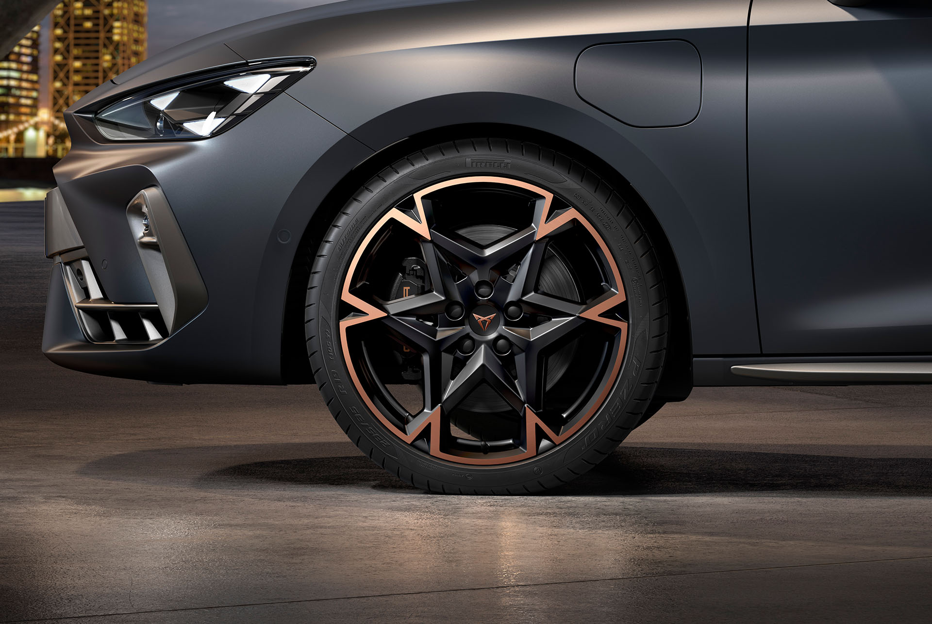 front side view of left machined alloy wheel in black and copper for the new cupra leon 2025, tyres, signature headlights and grey matt body